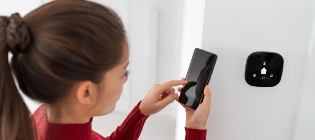 a girl using phone app in adjusting room's temperature