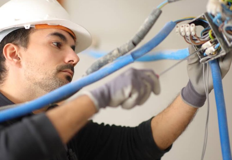 Electrician installing electrical system in a house under reform